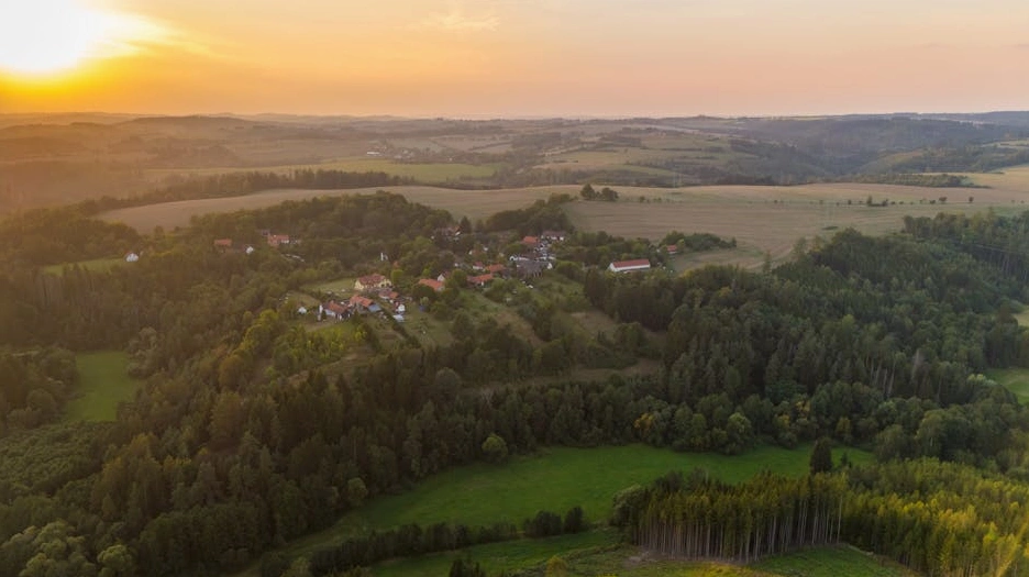 Vigneto toscano al tramonto con un casale in lontananza